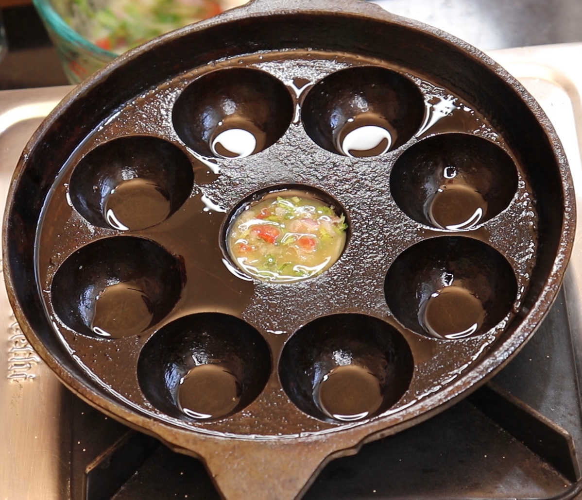 Heat Paniyaram pan and spoon in egg mixture