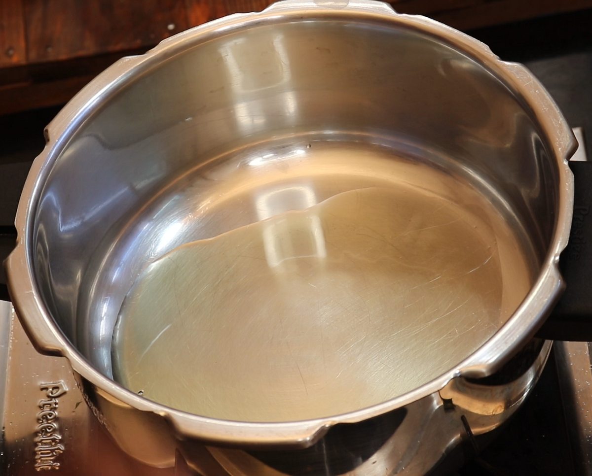 Heat oil in a Pressure cooker