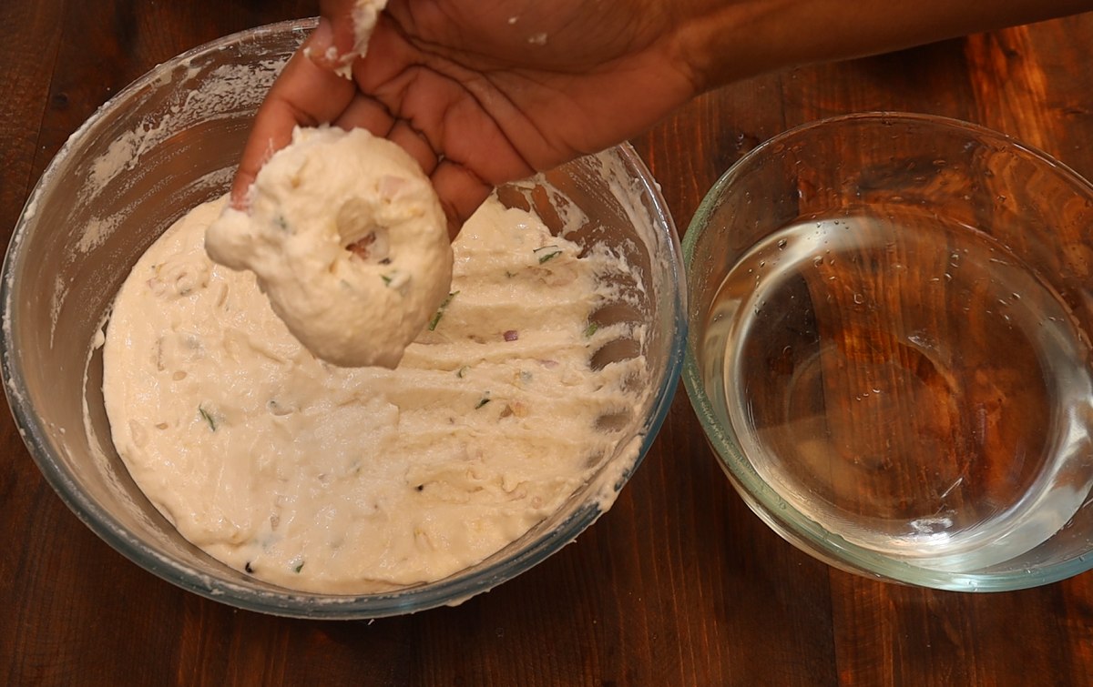 Take a ball of batter and shape them into donut shaped balls